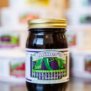 A jar of fruit jelly sitting on top of a table.