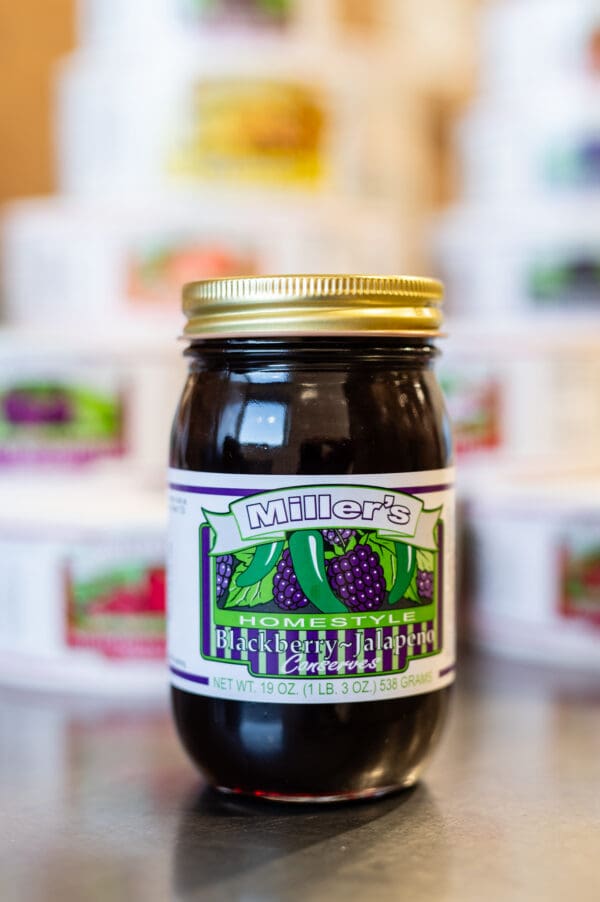 A jar of fruit jelly sitting on top of a table.