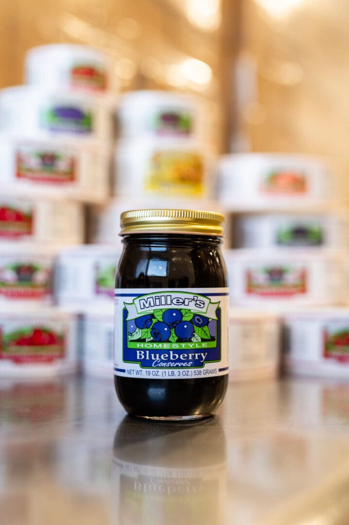 A jar of blueberry jam sitting on top of a table.