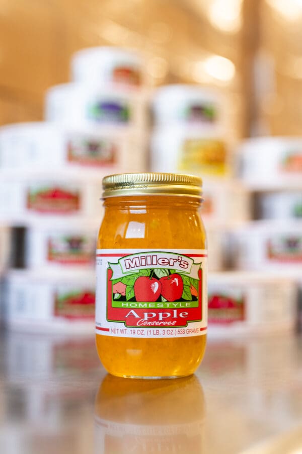 A jar of apple jelly sitting on top of a table.