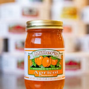 A jar of apricot jam sitting on top of a counter.