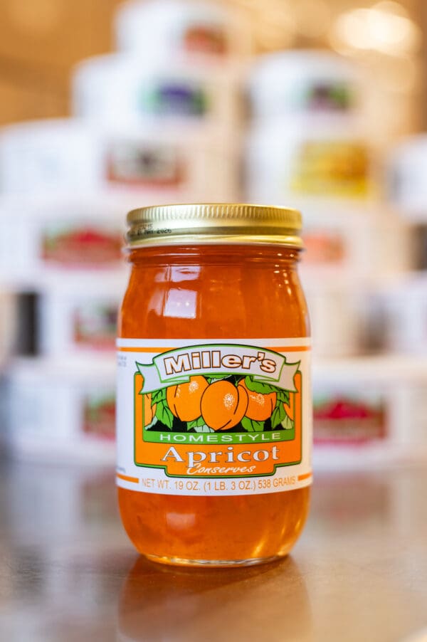 A jar of apricot jam sitting on top of a counter.