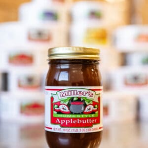 A jar of apple butter sitting on top of a table.