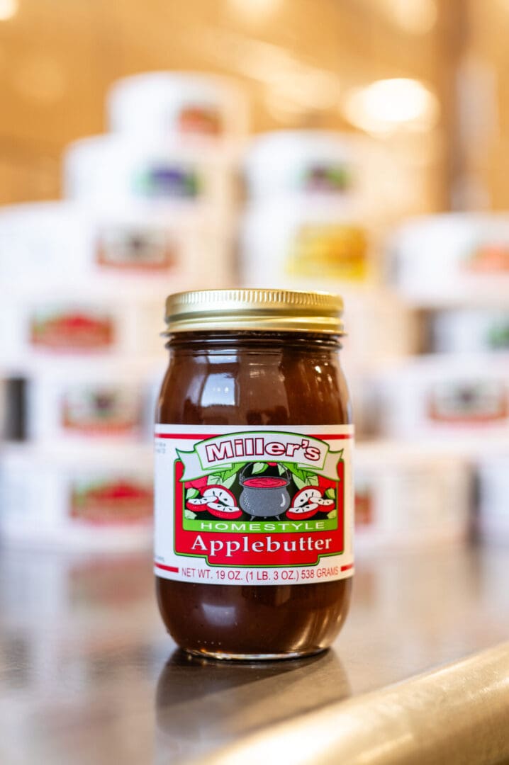 A jar of apple butter sitting on top of a table.