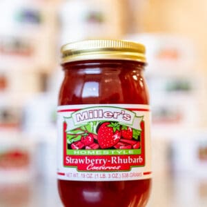 A jar of strawberry rhubarb condiments sitting on top of a table.