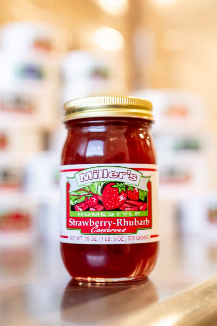 A jar of strawberry rhubarb condiments sitting on top of a table.