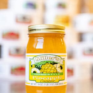 A jar of pineapple jelly sitting on top of a table.