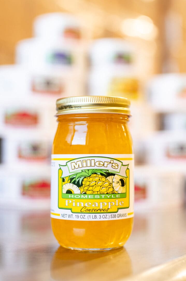 A jar of pineapple jelly sitting on top of a table.