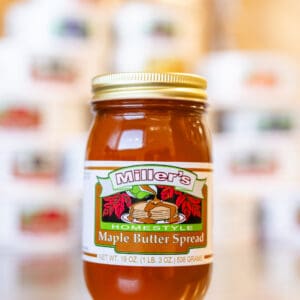 A jar of maple butter spread on the counter.