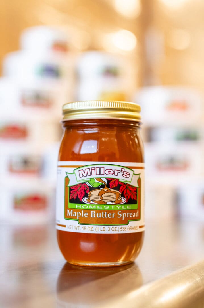 A jar of maple butter spread on the counter.