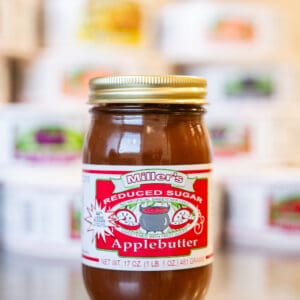 A jar of apple butter sitting on top of a table.