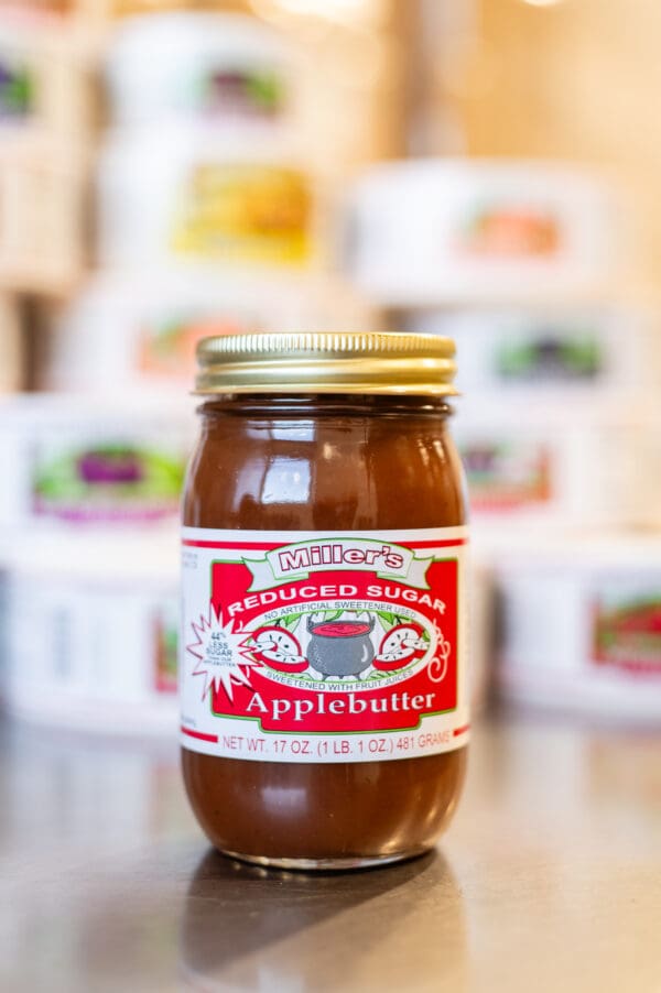 A jar of apple butter sitting on top of a table.