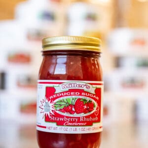 A jar of strawberry rhubarb preserves on display.