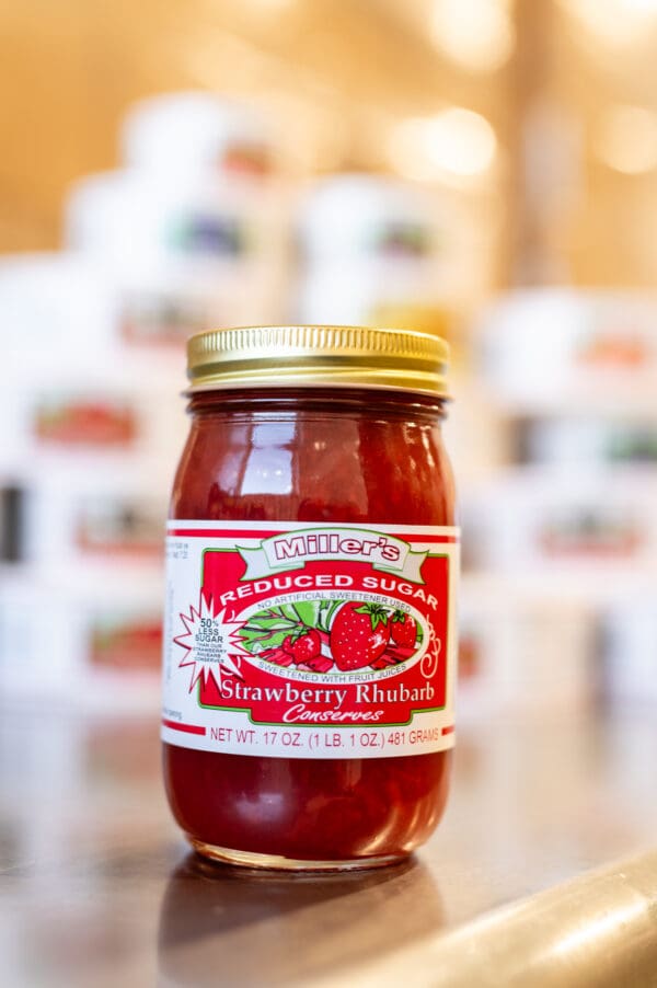 A jar of strawberry rhubarb preserves on display.