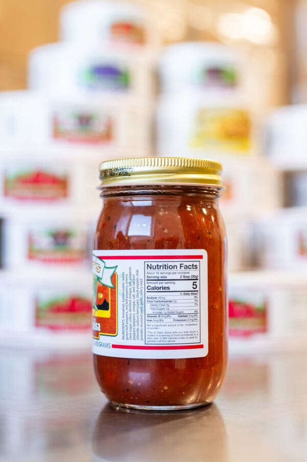 A jar of honey is shown in front of many other jars.