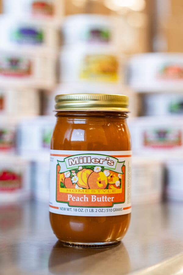 A jar of peach butter sitting on top of a counter.