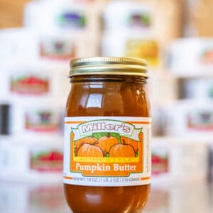 A jar of pumpkin butter sitting on top of a table.