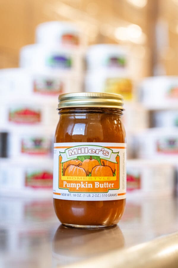 A jar of pumpkin butter sitting on top of a table.