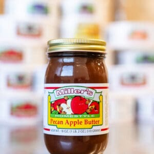 A jar of apple butter sitting on top of a table.