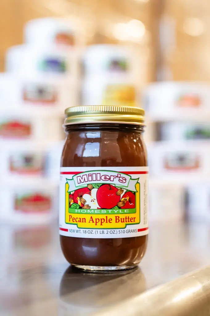 A jar of apple butter sitting on top of a table.