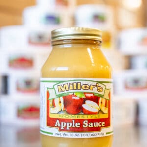 A jar of apple sauce sitting on top of a table.