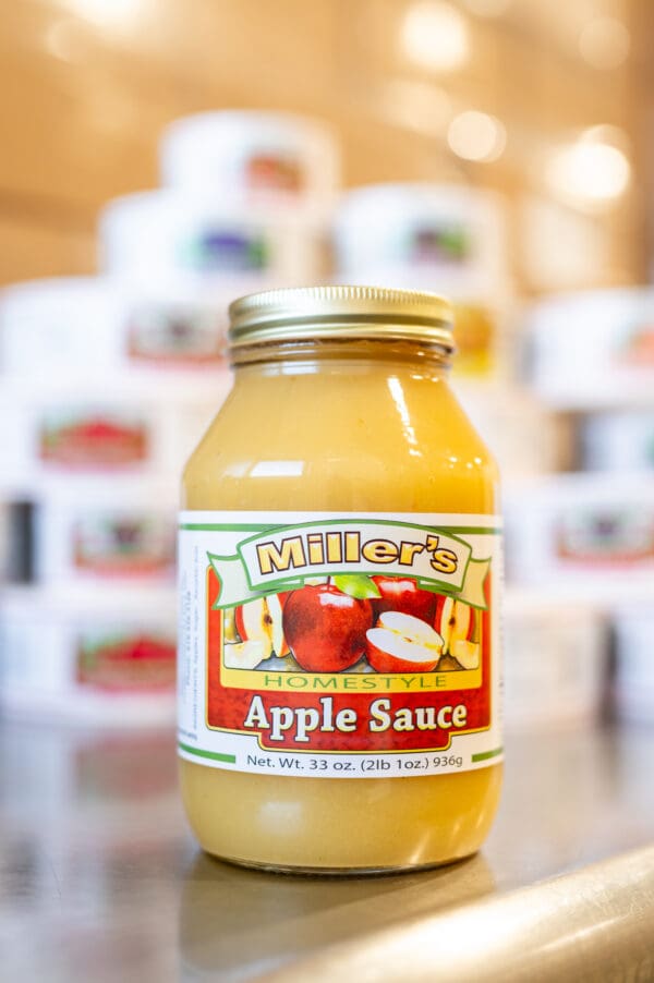 A jar of apple sauce sitting on top of a table.