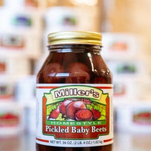 A jar of pickles is sitting on the counter.