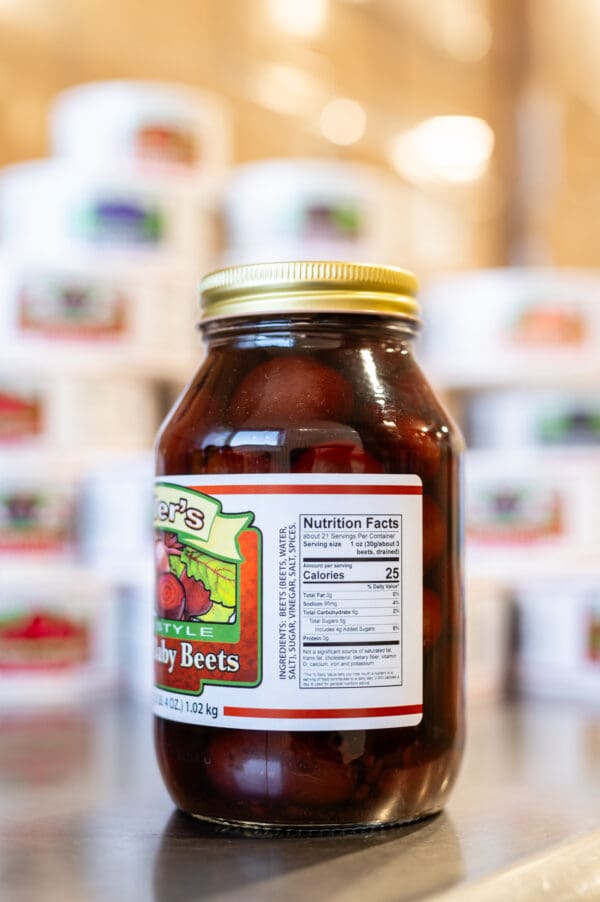 A jar of jelly beets sitting on top of a counter.