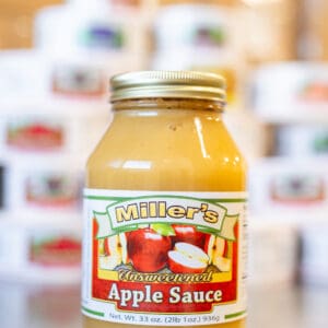 A jar of apple sauce on the counter.