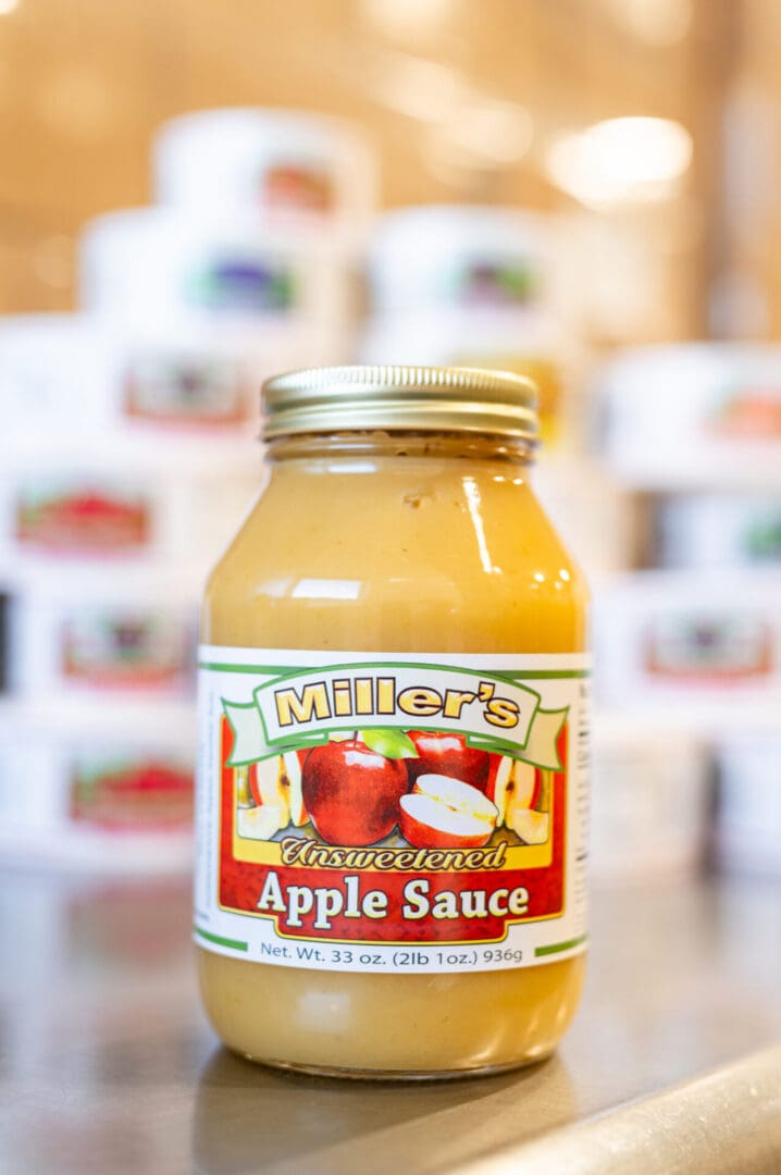 A jar of apple sauce on the counter.