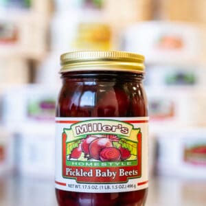 A jar of pickled baby beets on top of a table.