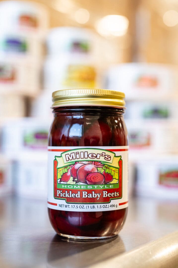 A jar of pickled baby beets on top of a table.