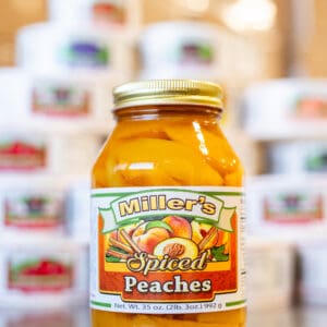 A jar of peaches sitting on top of a table.