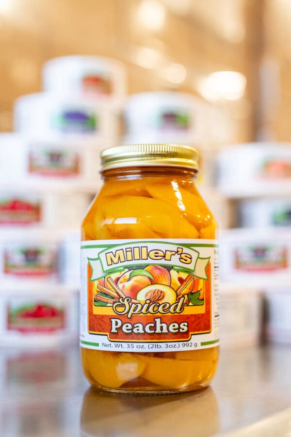 A jar of peaches sitting on top of a table.