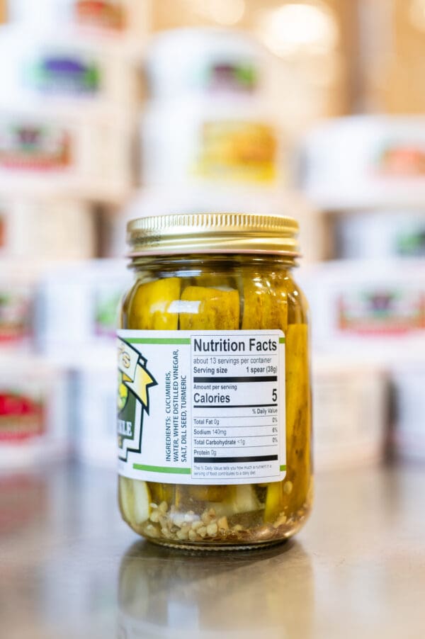 A jar of pickles sitting on top of a counter.