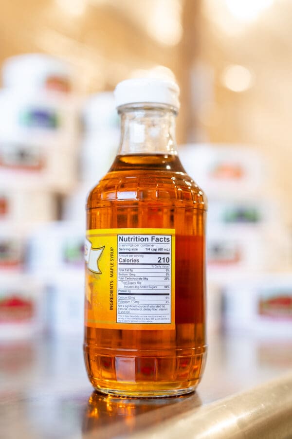 A bottle of syrup sitting on top of a counter.