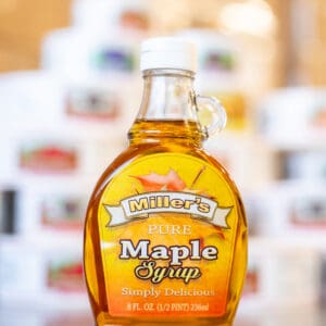 A bottle of maple syrup sitting on top of a table.