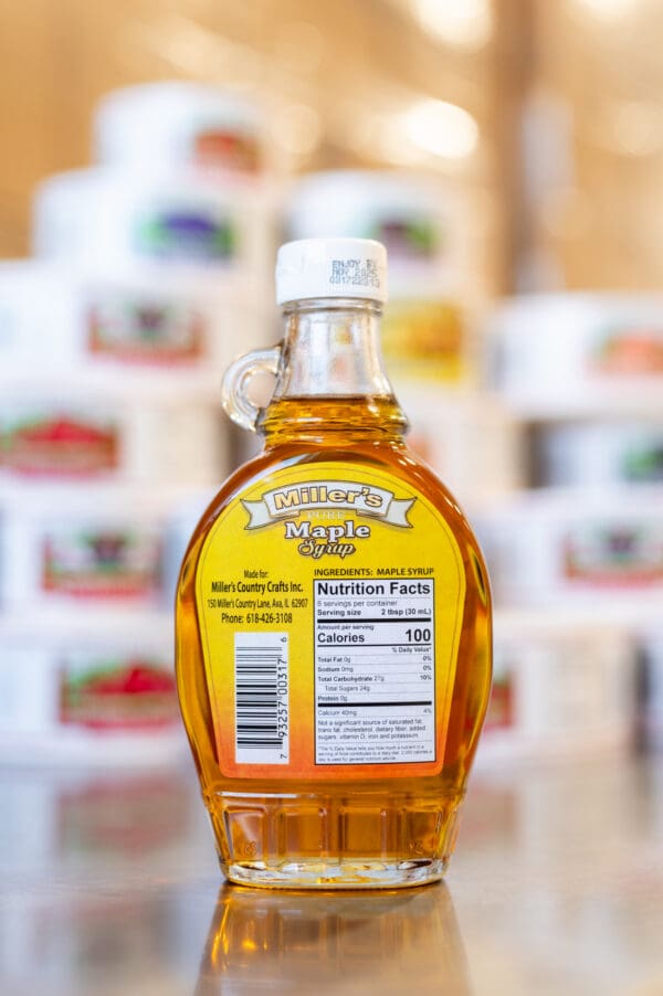 A bottle of maple syrup sitting on top of a counter.