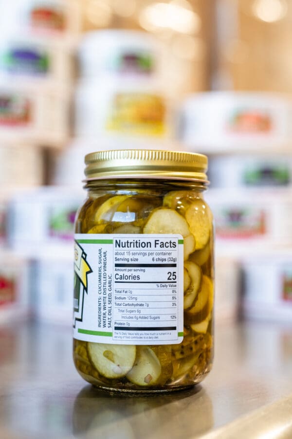 A jar of pickles sitting on top of a counter.