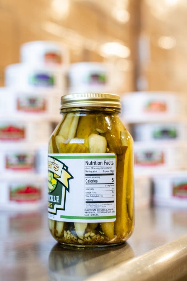 A jar of pickles sitting on top of a table.