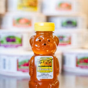 A jar of honey is sitting on the counter.