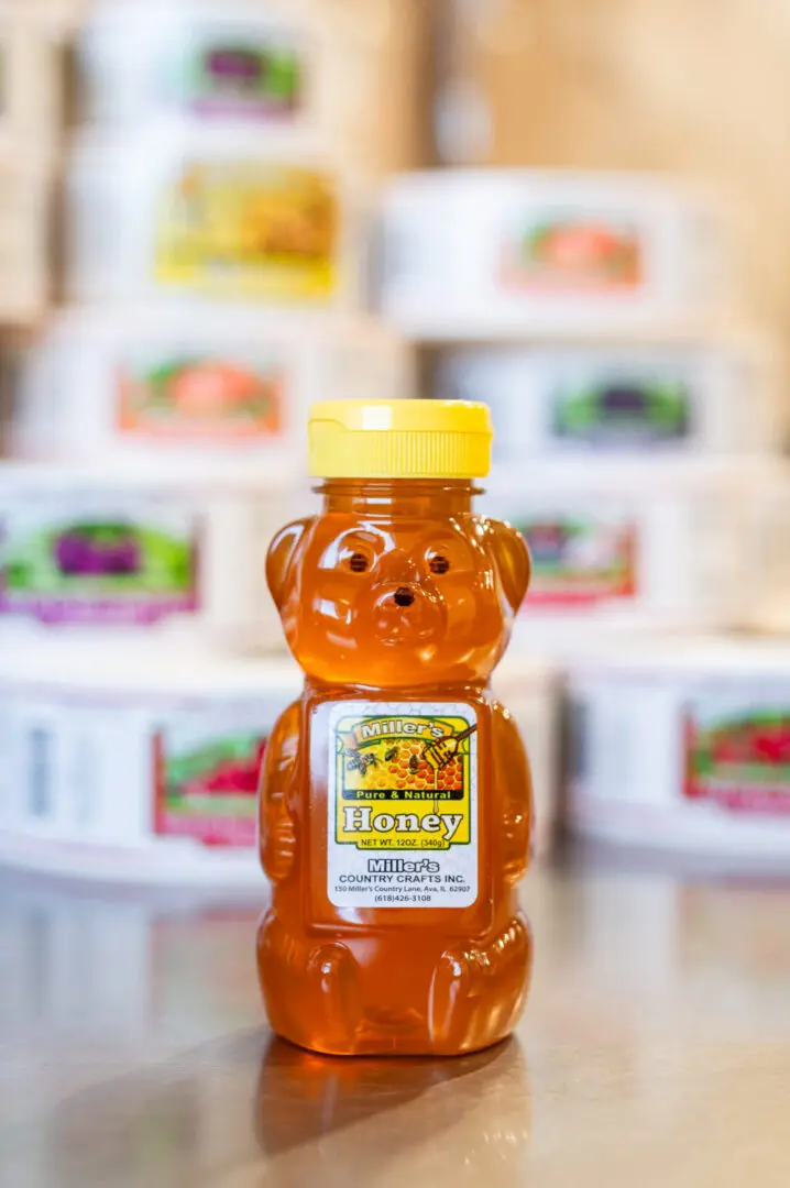 A jar of honey is sitting on the counter.