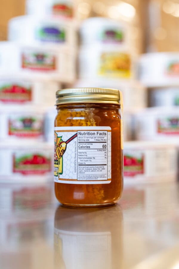 A jar of honey sitting on top of a table.