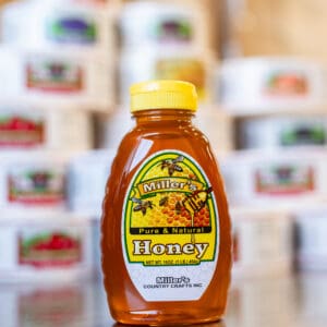 A bottle of honey sitting on top of a table.