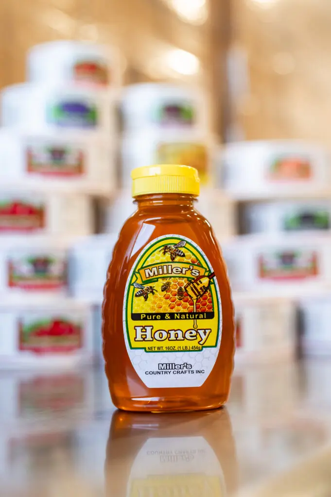 A bottle of honey sitting on top of a table.