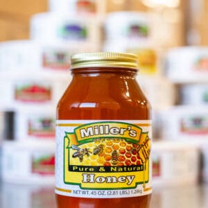 A jar of honey on top of a table.