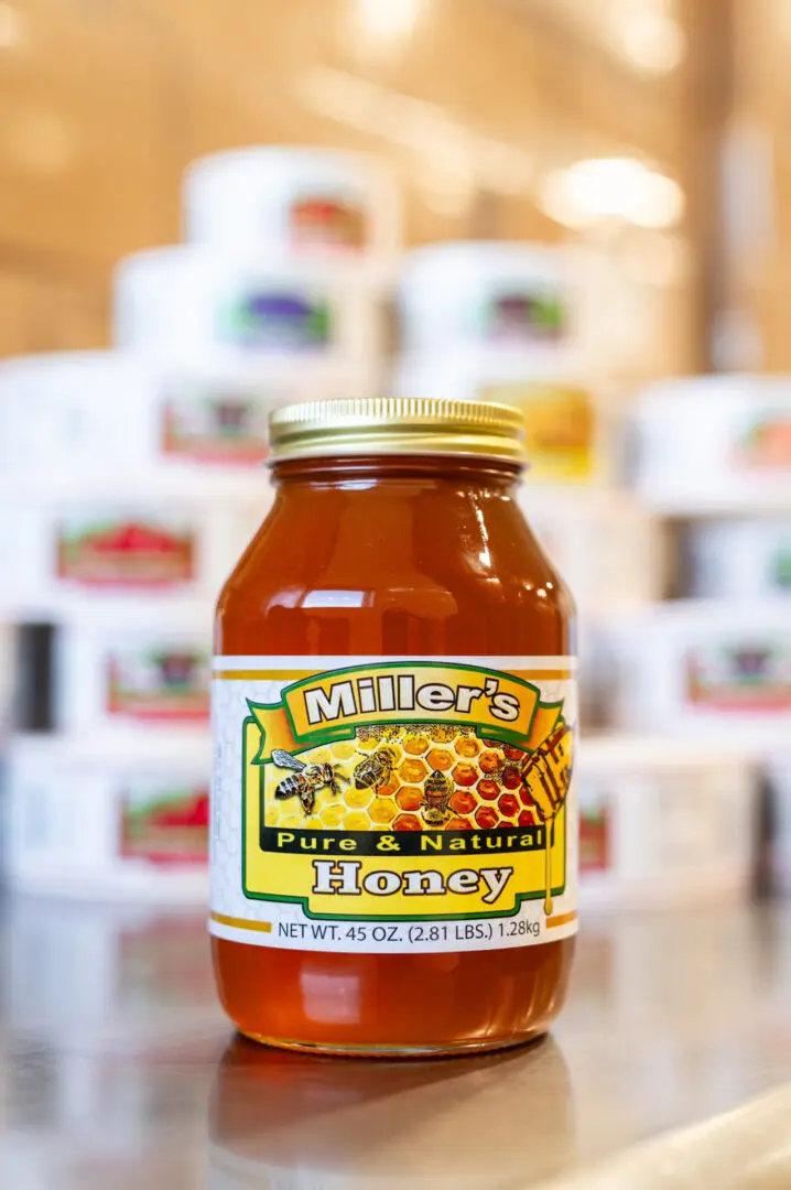 A jar of honey on top of a table.