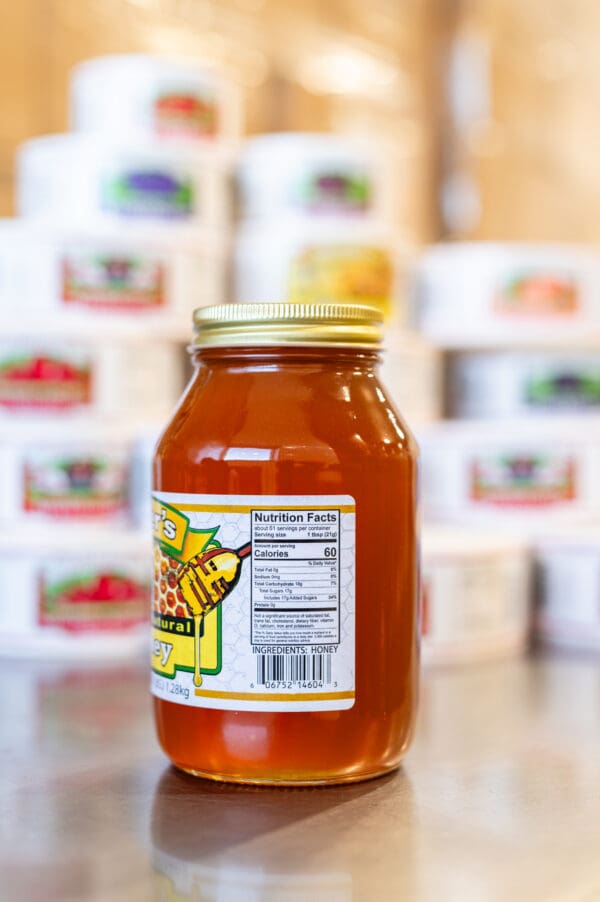 A jar of honey sitting on top of a table.