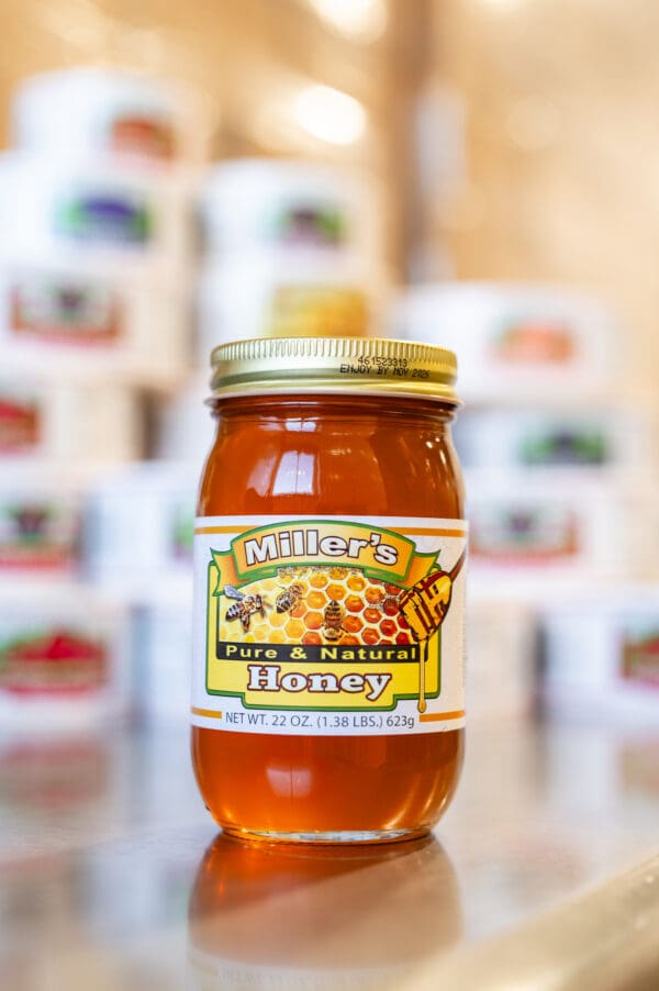 A jar of honey sitting on top of a table.